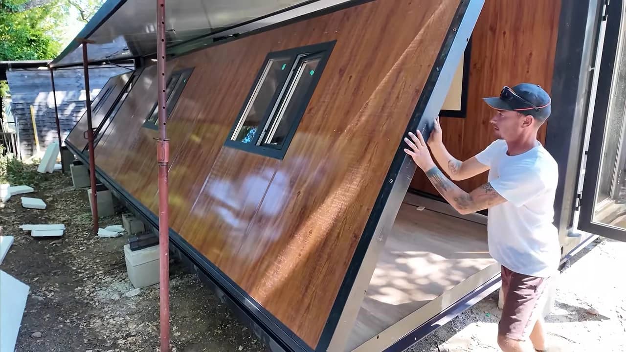 Une paroi extérieure avec fenêtre est ouverte pendant le déploiement d’un module de maison.
